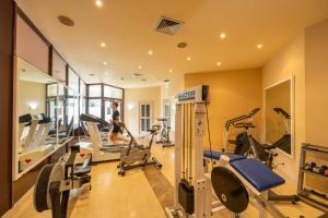 a gym with several tread machines and a woman in the background at Clube do Lago Hotel in Estoril