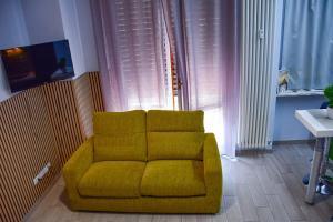 a yellow chair in a living room with a table at Casa Olimpo in Turin