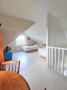 a attic room with two beds and a staircase at Haverdal Villa och sommarstuga in Haverdal