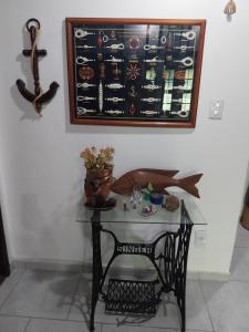 a small table with a glass table with a picture on the wall at Casa sonho sonhado in São Pedro da Aldeia