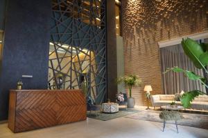 a lobby with a wooden reception desk in a building at Nakheel Residence Sabah Alsalem by House living in Kuwait