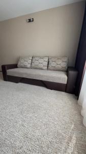 a couch in the corner of a room with a carpet at Z - apartment in Valmiera