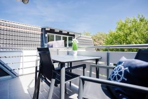 a patio table and chairs on a balcony at DER STÖRTEBEKER - "Apartment Dierhagen" Apartments hinter den Dünen in Dierhagen