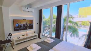 a bedroom with a tv and a large window at STAY Mezarina Apt 2 in Ayia Napa