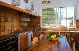 a kitchen with a wooden table with a basket of fruit on it at Chalet Los 20 Pilares in Ubrique