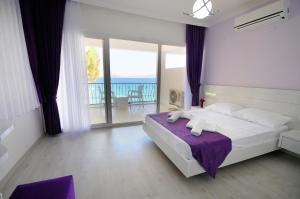 a bedroom with a large bed and a balcony at Fuda Hotel in Datca