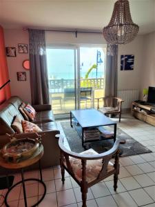 a living room with a couch and a table at Plazza front de Mer in Villers-sur-Mer