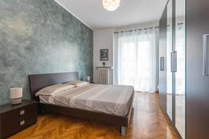 1 dormitorio con cama y ventana grande en Moderno Appartamento in Cenisia en Turín