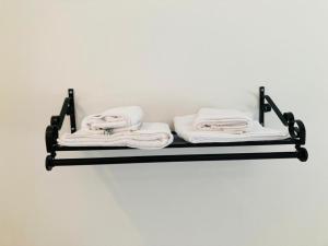 a black shelf with white towels on a wall at Oak Lodge in Stapleford Tawney