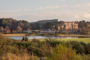 a view of a lake with a building in the background at Gowrie Farm Golf Lodge in Nottingham Road