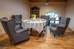a dining room with a white table and chairs at Vecpiebalgas Dzirnavas in Vecpiebalga