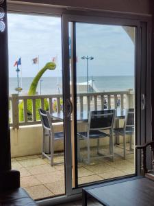 a view of the ocean from a balcony with a table and chairs at Plazza front de Mer in Villers-sur-Mer