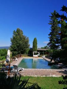een zwembad met 2 stoelen en een volleybal bij Podere Le Rote in Montecastelli