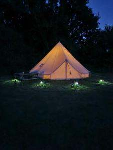a tent with lights in a field at night at Glamping in style Bell tent in Ifield