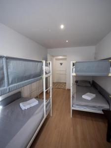 a room with two bunk beds and a hallway at La Maison des Hôtes in La Motte-du-Caire