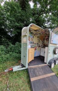 a small trailer with a door open in the grass at Glamping in style Bell tent in Ifield