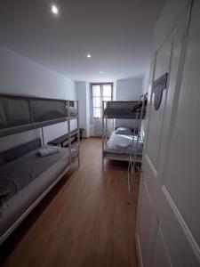 a room with two bunk beds and a door at La Maison des Hôtes in La Motte-du-Caire