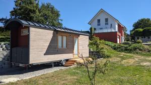 a tiny house sitting in a yard next to a house at Tiny Haus - Himmelreich 