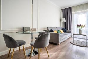 sala de estar con mesa, sillas y sofá en Mennica Residence by Golden Apartments, en Varsovia