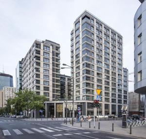 dos edificios altos en una calle en una ciudad en Mennica Residence by Golden Apartments, en Varsovia