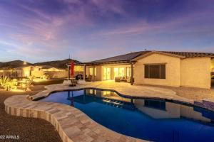 a home with a swimming pool and a house at Phoenix Home with heated pool, desert views & hot tub in Anthem