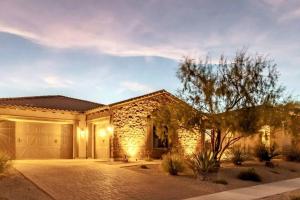 a stone house with a garage at Phoenix Home with heated pool, desert views & hot tub in Anthem