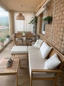 a room with beds and tables and a brick wall at Apartamento Benicàssim Sunset Calm&Views in Benicàssim