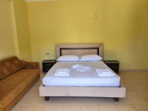 1 dormitorio con 1 cama y 1 sofá en Amelia Apartments en Ksamil
