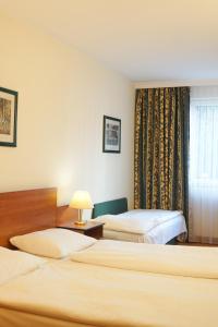 ein Hotelzimmer mit 2 Betten und einem Fenster in der Unterkunft Hotel Deutschmeister in Wien