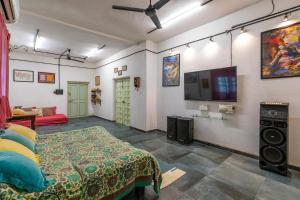 sala de estar con TV en la pared en StayVista's Suman Vatika - Pench - Outdoor Pool, Jacuzzi, Rainshower & Terrace, en Khawāsa