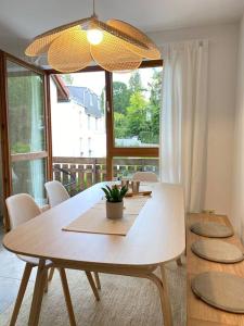 a dining room table with chairs and a large window at Traumurlaub WestCoast Ammersee 7 Gehminuten zum See in Schondorf am Ammersee
