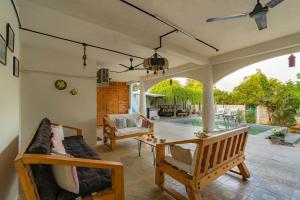 un patio con sofá y mesa en StayVista's Suman Vatika - Pench - Outdoor Pool, Jacuzzi, Rainshower & Terrace, en Khawāsa