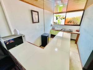 um pequeno quarto com uma mesa branca e uma janela em Apart Hotel Gufo La Fortuna, Arenal Volcano em La Fortuna