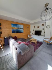 a living room with a couch and a tv at Les Mouflons in Le Mont-Dore