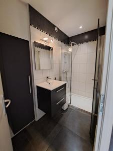 a bathroom with a sink and a shower at Hôtel Les Mouflons in Le Mont-Dore