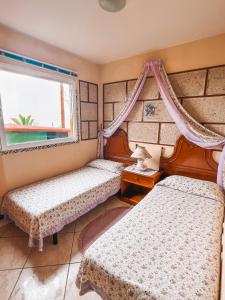 um quarto com 2 camas e uma janela em Apartment with Huge Deck Nestled in Marvelous Gardens - Nidos em La Orotava
