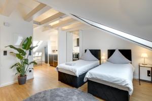 2 Betten in einem Zimmer mit einer Treppe in der Unterkunft George Apartment in Düsseldorf