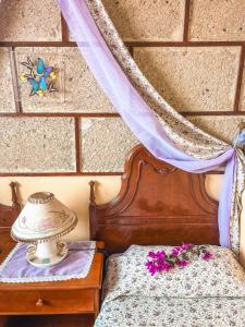 um quarto com uma cama com flores roxas em Apartment with Huge Deck Nestled in Marvelous Gardens - Nidos em La Orotava