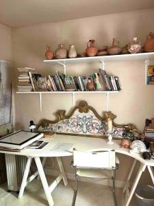 Loft à Gammarth في قمرت: غرفة بها مكتب ورفوف مع كتب
