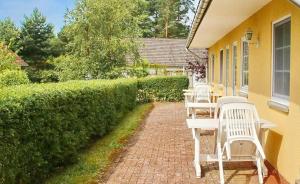 a group of white chairs sitting on a brick patio at Ferienpark am Darß - Apartmenthaus 2 in Fuhlendorf