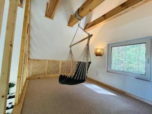 a room with a hammock hanging from the ceiling at Namelis Strazdas in Molėtai