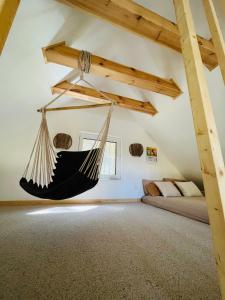 a room with a hammock in a attic at Namelis Strazdas in Molėtai