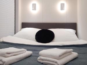 a bedroom with a bed with towels on it at Dom na wodzie LaMare Modern 14 in Bydgoszcz