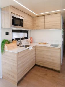 a kitchen with wooden cabinets and a sink at Dom na wodzie LaMare Modern 14 in Bydgoszcz