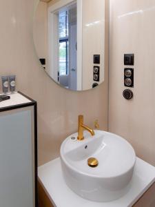 W łazience znajduje się biała umywalka i lustro. w obiekcie Dom na wodzie LaMare Modern 14 w Bydgoszczy