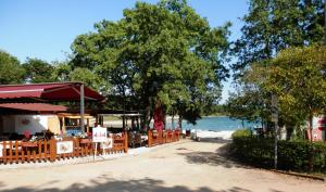 a patio with tables and chairs next to the water at Easyatent Safari tent Bijela Uvala in Poreč