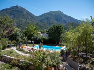 a view of a swimming pool with mountains in the background at La Maison des Hôtes in La Motte-du-Caire