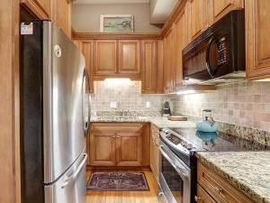eine Küche mit Holzschränken und einem Kühlschrank aus Edelstahl in der Unterkunft Hideaway on Jones in Savannah