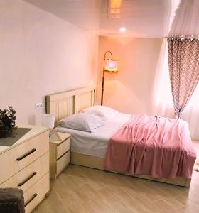 a bedroom with a bed and a dresser and a window at Apartment 19 in Kutaisi