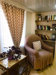 a living room with a chair and a table and a window at Apartment 19 in Kutaisi